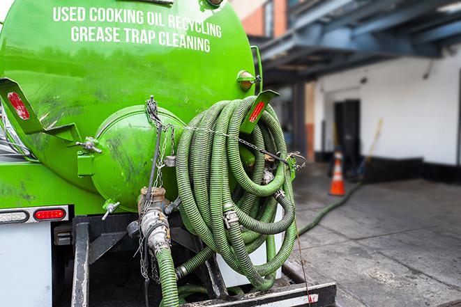 a professional technician pumping a restaurant's grease trap in Buda TX